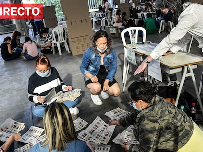 People count ballots at a polling station after votation closed in Medellin, Colombia during the presidential election, on May 29, 2022. - Colombians started voting Sunday in a first round of presidential elections, with a leftist poised for victory for the first time in the country's troubled history. (Photo by JOAQUIN SARMIENTO / AFP)