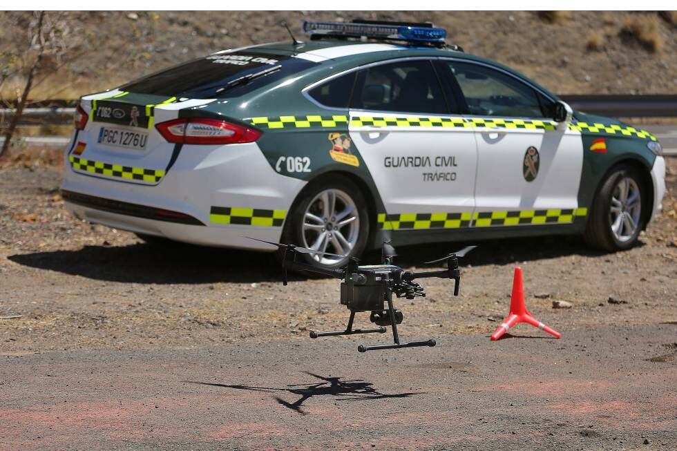 Arriba, un dron de la DGT delante de un coche de la Guardia Civil.