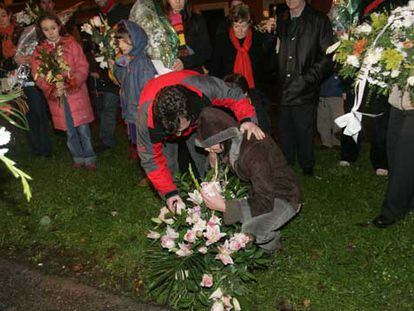 Los padres de los niños fallecidos colocan un ramo de flores en el lugar donde se produjo el accidente.