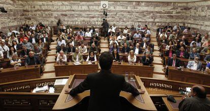 El líder de Syriza, Alexis Tsipras, de espaldas, ayer en el Parlamento griego.