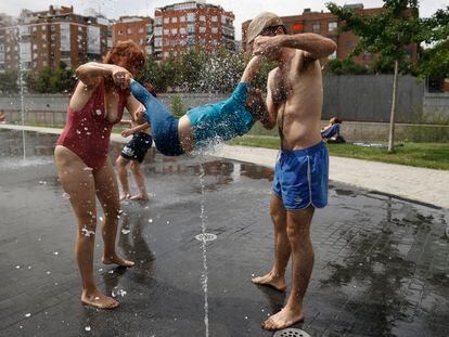 MADRID, 12/06/2022.- Una familia juega en la fuente de un parque en Madrid este domingo. El calor sigue azotando a gran parte de España, una situación que, según todos los pronósticos, se mantendrá durante varios días, con temperaturas muy elevadas para esta época del año que obligan a extremar las precauciones. EFE/ Mariscal
