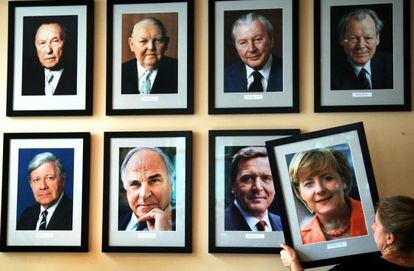 Una mujer cuelga un retrato de Merkel hace cinco a&ntilde;os.