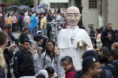 Fieles caminan alrededor de una imagen del papa Francisco durante su visita a la favela Varginha en Río de Janeiro. Pidió a los poderes públicos que trabajen por un mundo más justo y solidario.