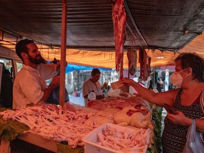 Una clienta compra carne en un mercado callejero de Río de Janeiro el pasado abril.