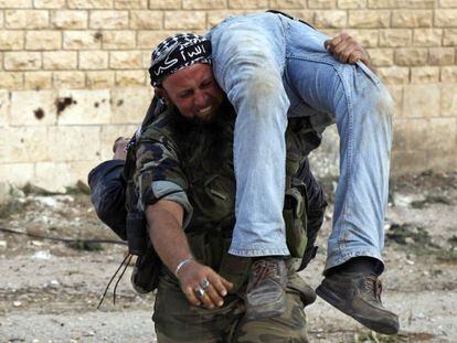 Un miliciano del Ej&eacute;rcito Libre de Siria traslada el cad&aacute;ver de un compa&ntilde;ero, el s&aacute;bado. 
