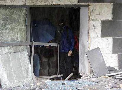 Dos agentes de la policía científica de la Ertzaintza observan los destrozos en la empresa Amenabar.