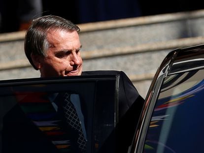 Jair Bolsonaro se sube a un vehículo tras asistir a una misa en una iglesia católica en Brasilia, este jueves.