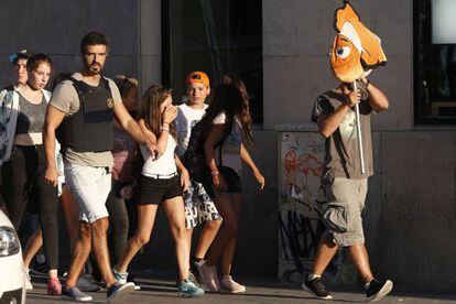Un policía conduce a unos niños a un área segura tras el atentado en Barcelona.