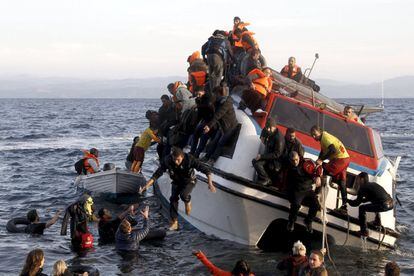 Refugiados, la mayoría sirios, tratan de abandonar el barco en el que viajaban hacia Grecia, que naufragó frente a la isla de Lesbos.