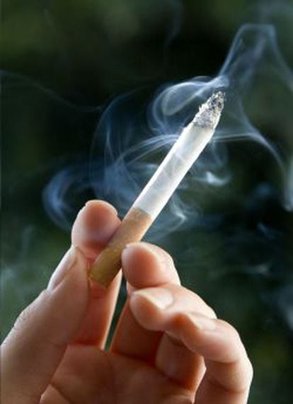 Un fumador sostiene un cigarrillo