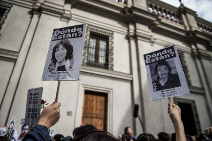 Activistas de la organización chilena de derechos humanos 'Personas detenidas y desaparecidas' muestran fotografías de desaparecidos frente al palacio presidencial de La Moneda, en Santiago.