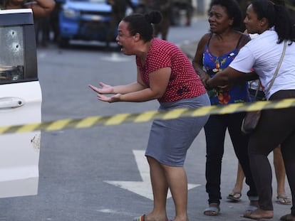 La esposa del músico Evaldo dos Santos brasileño, asesinado por las fuerzas armadas brasileñas, grita de dolor al ver el cuerpo de su esposo desplomado sobre el asiento del vehículo, en Río de Janeiro.