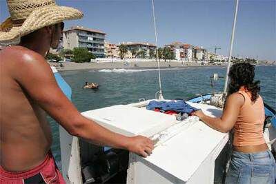Uno de los barcos encargados de limpiar las playas de medusas rastrea la costa de Málaga.