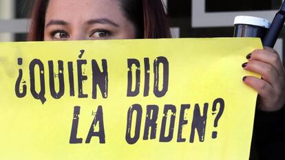Una mujer sostiene un cartel de protesta frente a la JEP, en Bogotá.