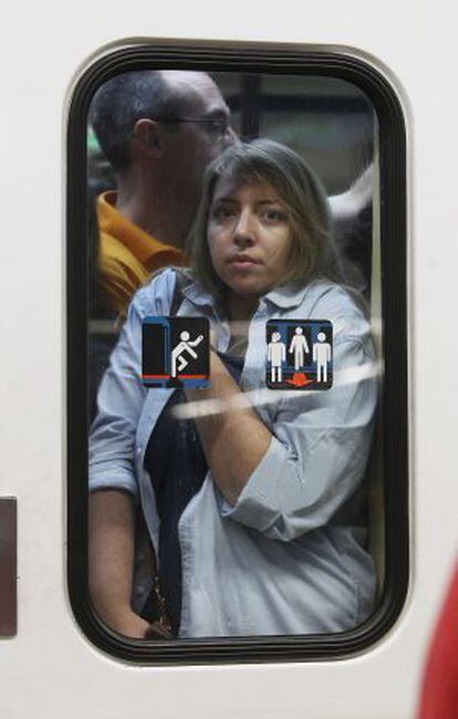 Mujer tras la puerta de un vagón abarrotado.