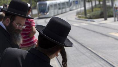 Pasajeros jud&iacute;os esperan el tranv&iacute;a en Jerusal&eacute;n en agosto. 