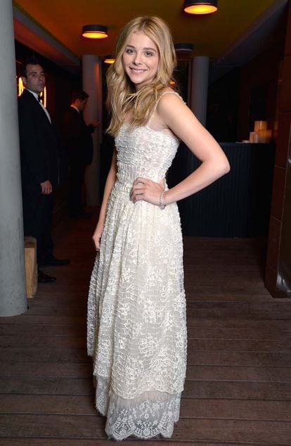 El elenco de Clouds of sils María disfrutó en Cannes de una cena organizada por Chanel. Moretz eligió un vestido de encaje blanco roto de la maison. Su ondas rubias restan formalidad al look y le aportan un toque desenfadado.