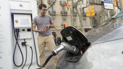 Un usuario de coche eléctrico recarga las baterías de su vehículo en Barcelona. 