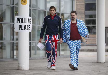 Un hombre vestido con unos pantalones de la bandera del Reino Unido y otro con un traje con un patrón como la bandera de Escocia se disponen a votar en un colegio electoral en Stirling.