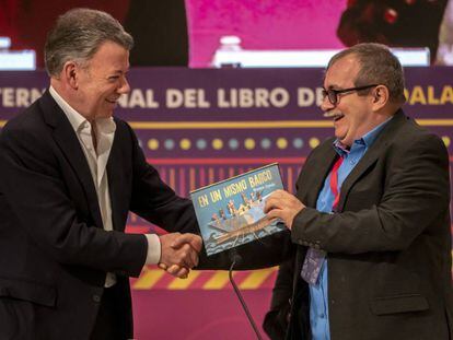 Timochenko recibe de Juan Manuel Santos un libro infantil para su hijo, tras el encuentro que mantuvieron en la FIL. 