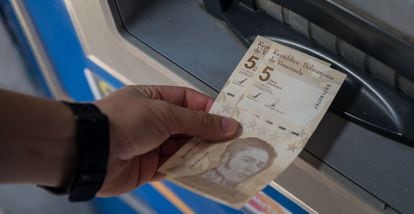 Una persona saca dos billetes de 5 bolívares digitales, la nueva divisa venezolana, este viernes en Caracas.