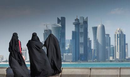 Tres mujeres árabes observan el skyline de Doha, en Qatar.