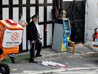 Un hombre, junto a una prenda ensangrentada en el lugar del ataque, este sábado en Jerusalén.