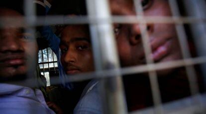 Un grupo de hombres de la minoría rohinyá mira desde el interior de un vehículo de la policía en Myanmar.