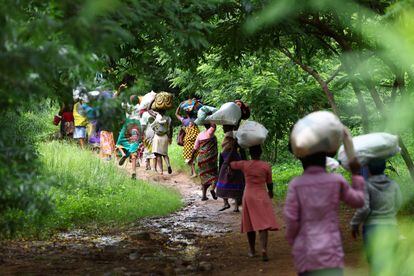Víctimas de las inundaciones de la aldea de Mtauchira cargan con los alimentos que el gobierno de Malawi les ha facilitado, tras el paso del ciclón que destruyó sus hogares, este miércoles en Blantyre.