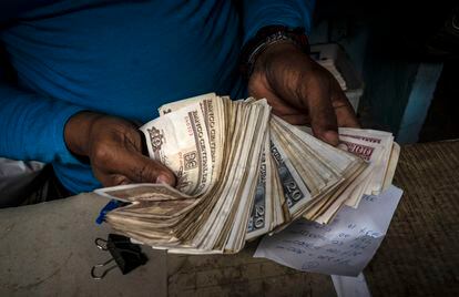 Un trabajador muestra billetes de pesos cubanos en La Habana.