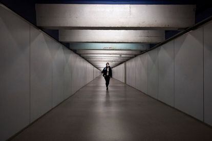 Una pasajera camina por la zona de trasbordo de la estación de metro de Paseo de Gracia, de Barcelona, este martes, cuando se cumple el decimoséptimo día del estado de alarma decretado por el Gobierno por la pandemia de coronavirus.