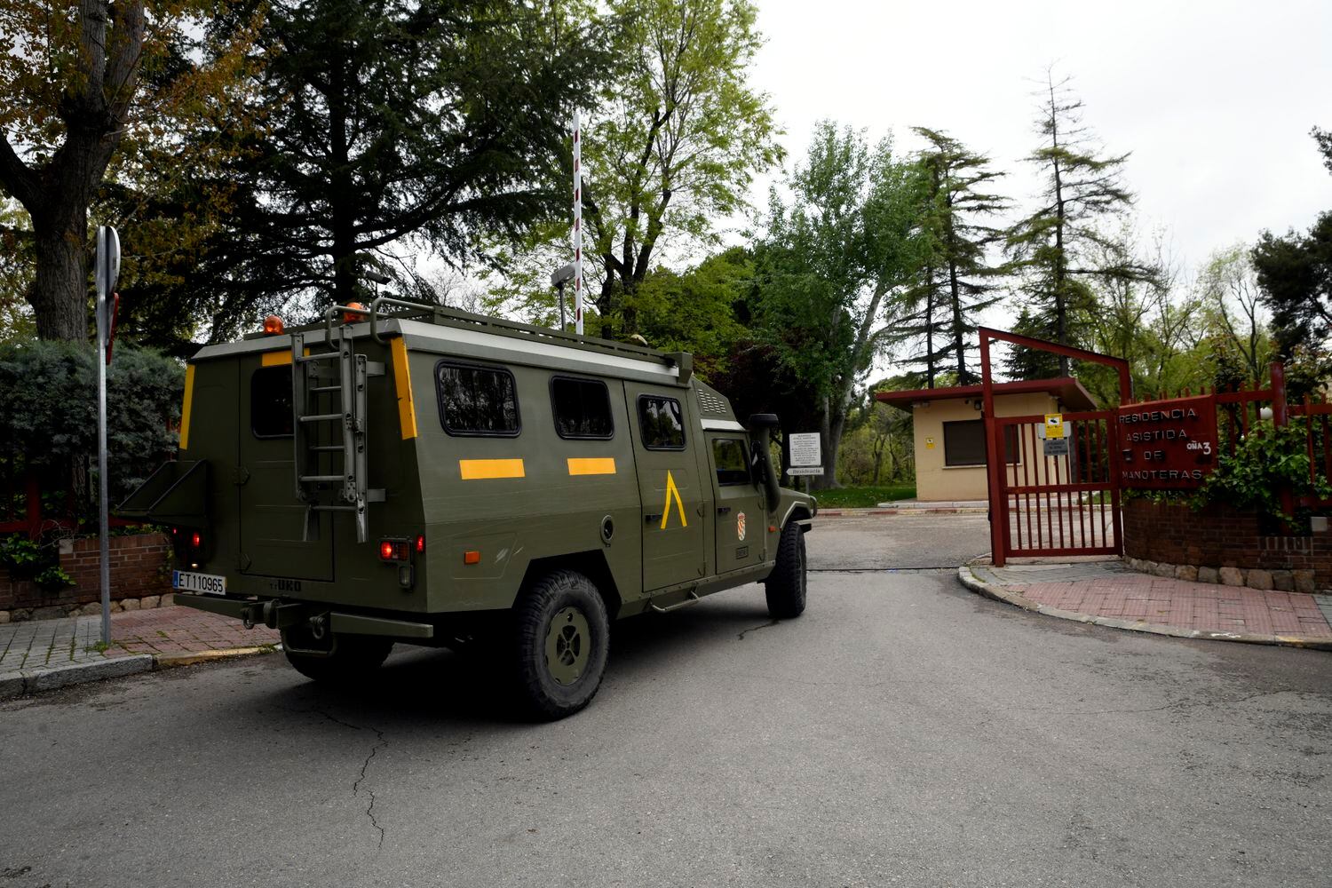 Un furgón militar de la Unidad Militar de Emergencia (UME) entra por la puerta de la residencia de Mayores 'Manoteras', en Madrid, donde los efectivos llevan a cabo labores de desinfección.