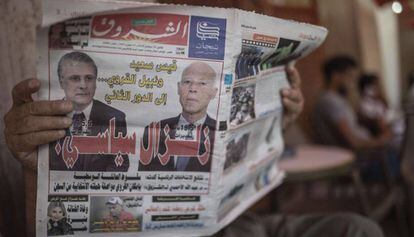 Un hombre lee un diario con la imagen de los dos candidatos que irán a la segunda vuelta de las presidenciales, Kaïs Saïd (derecha) y Nabil Karoui.