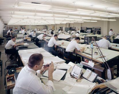 Un hombre se enciende una pipa en una oficina de arquitectos de los años sesenta en Estados Unidos.