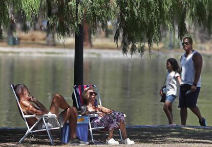 Una pareja descansa bajo la sombra de los árboles del parque Bosques de Palermo, en Buenos Aires, este jueves. El récord de temperatura disparó el consumo de electricidad y provocó fallas técnicas y desperfectos en la red que derivaron en un gran apagón que afectó a más de 700.000 personas en la capital del país.