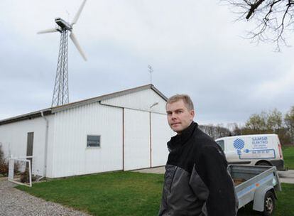 Un vecino de la isla danesa de Samsø, ante un molino de viento.
