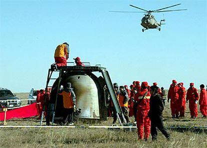 Un equipo de técnicos examina la cápsula espacial tras el aterrizaje en Mongolia Interior.