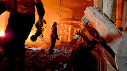Personal de emergencias permanecen entre los escombros de un edificio bombardeado por Israel, este lunes en Rafah. 