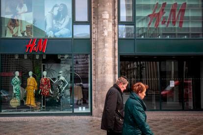 Dos personas pasan ante una tienda de H&M cerrada en Berlín.