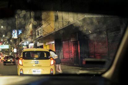 Una joven que ejerce el trabajo sexual se ofrece a un auto que pasa por la zona de la comuna 14 en Medellín.