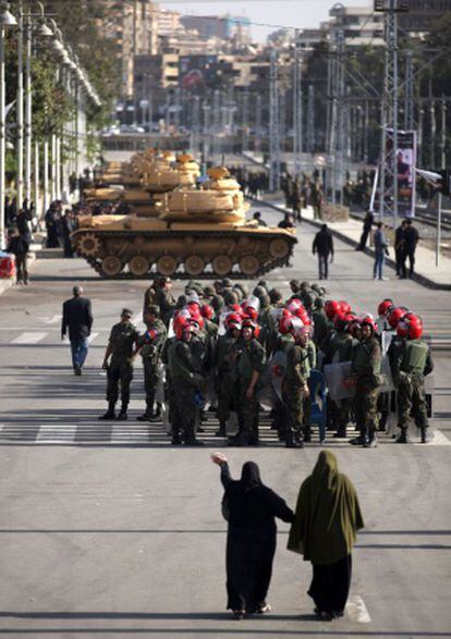 Dos mujeres se dirigen a los agentes que protegen el palacio presidencial en El Cairo.