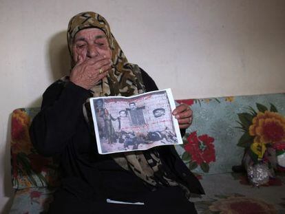 Una superviviente muestra una foto suya junto a los cad&aacute;veres de su familia. 
