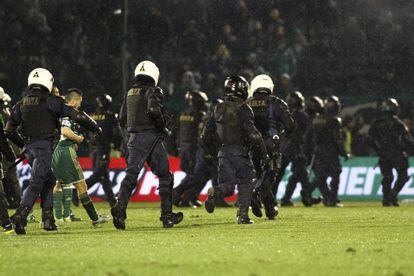 Agentes antidisturbios protegen a los jugadores en el Panathinaikos-Olympiacos .