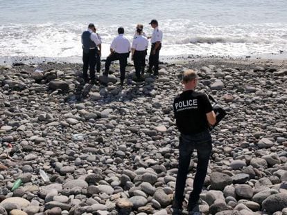 Varios polic&iacute;as inspeccionan un objeto met&aacute;lico hallado en la playa de Saint-Denis, en la isla de Reunion, el 2 de agosto.  
