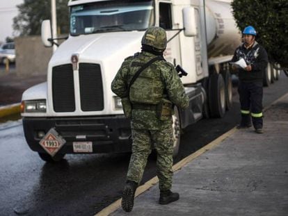 Un soldado supervisa los camiones de transporte de combustible, este viernes en Hidalgo. En vídeo, López Obrador defiende su plan contra el robo de combustibles.