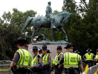 Miembros de la policía estatal de Virginia bajo una estatua de Robert E. Lee antes de una reunión de supremacistas blancos en Charlottesville, Virginia
