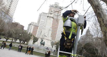 Un operario instala una cámara de vigilancia en la plaza de España.