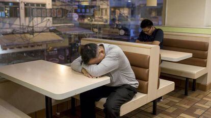 Dos hombres duermen en un establecimiento de comida r&aacute;pida.