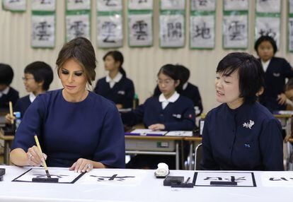 Melania Trump utiliza un pincel para escribir la palabra 'paz' mientras la primera dama nipona, Akie Abe, la observa durante una clase de caligrafía de alumnos del colegio Kyobashi Tsukiji en Tokio, el 6 de noviembre de 2017.