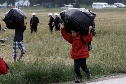 Un niño refugiado lleva sus pertenencias durante una operación policial en un campamento de refugiados en la frontera entre Grecia y Macedonia, cerca de Idomeni.